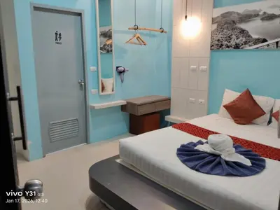 a bedroom with two beds and a door with a hat on it at Hotel The Journey Patong New in Patong Beach