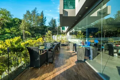 a restaurant with tables and chairs on a balcony at Studio with pool access - Twin Sands by Lofty in Patong Beach