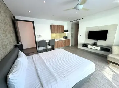 a bedroom with a bed and a television and a couch at Studio with pool access - Twin Sands by Lofty in Patong Beach