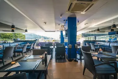 a dining room with tables and chairs in a restaurant at Studio with pool access - Twin Sands by Lofty in Patong Beach
