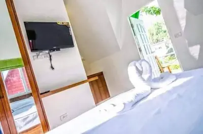 a room with a bed with a tv and a mirror at Mountain View Resort and Phupha Srirung Resort in Phuket Town