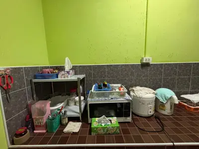 a kitchen with a microwave on the floor at Baan Ja Da in Ban Nai Khlong
