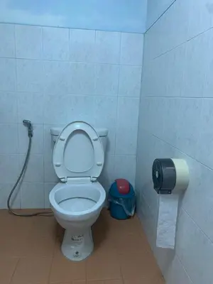 a bathroom with a toilet with a toilet paper dispenser at Baan Ja Da in Ban Nai Khlong