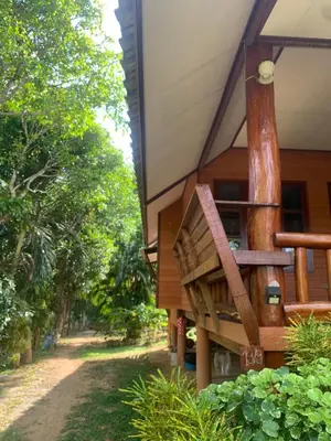 a porch of a house with a tree at Baan Ja Da in Ban Nai Khlong