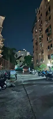 a city street at night with parked motorcycles and buildings at Sleep tight Patong in Patong Beach