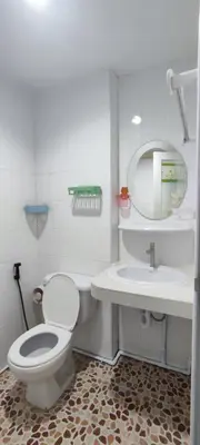a white bathroom with a toilet and a sink at Sleep tight Patong in Patong Beach