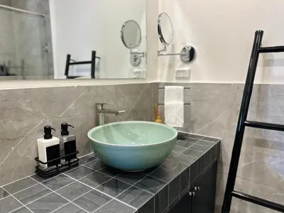 a bathroom with a green bowl sink on a counter at Gloria’s Home in Kamala Beach