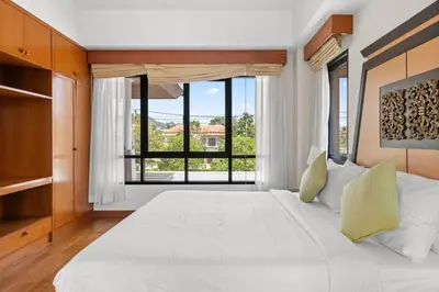 a bedroom with a large white bed with a large window at Laguna Lakeview Villa in Layan Beach