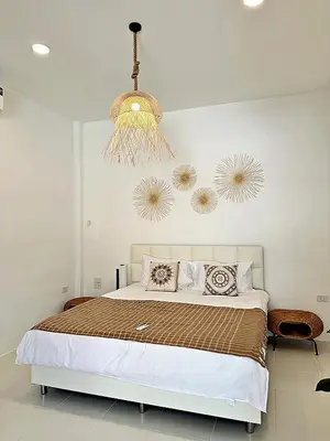 a bedroom with a bed and a chandelier at 2BR Pool Villa&Garden - Bali style by La Perla Phuket Rawai in Ban Saiyuan (1)