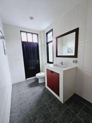 a bathroom with a toilet and a sink and a mirror at KRAAM VILLAS in Thalang