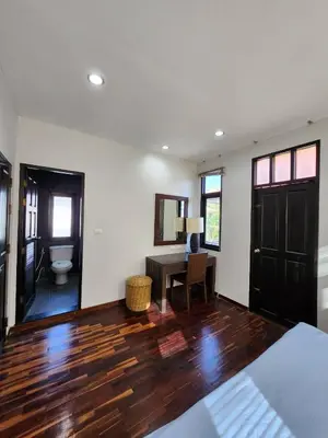 a bedroom with a desk and a table in a room at KRAAM VILLAS in Thalang
