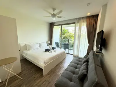 a bedroom with a bed and a tv and a couch at Private apartment at Oceana Resort by Lofty in Kamala Beach