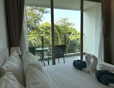 a bedroom with a bed with a view of a balcony at Private apartment at Oceana Resort by Lofty in Kamala Beach