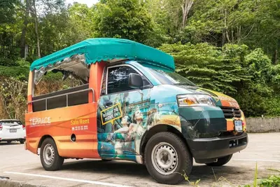 a van with an open door in a parking lot at Private apartment at Emerald Terrace in Patong Beach