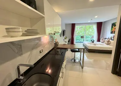 a kitchen with a counter and a table in a room at Private apartment at Emerald Terrace in Patong Beach