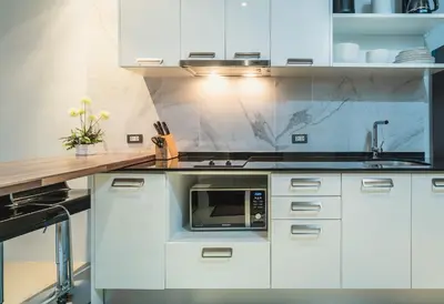 a kitchen with white cabinets and a microwave at Private apartment at Emerald Terrace in Patong Beach