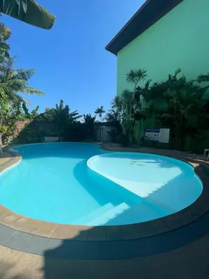 a large blue swimming pool in front of a building at Studio 1 Chambre lumineux avec vue à 180° in Ban Klang