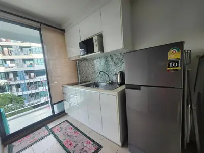 a kitchen with a stainless steel refrigerator and a window at 中央公寓 1 bed & Twin beds in Ban Rangeng