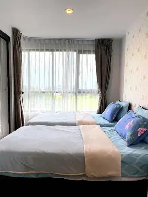 a bedroom with two beds and a large window at 中央公寓 1 bed & Twin beds in Ban Rangeng