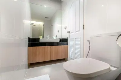 a white bathroom with a toilet and a sink at The Lago apartments 2bd in Phuket Town