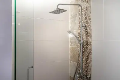 a shower with a glass door in a bathroom at The Lago apartments 2bd in Phuket Town