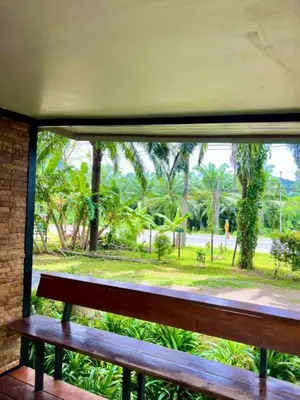 a bench looking out of a window at a park at Lay Back Villa Wooden House AC Hot shower High Speed Internet in Krabi town