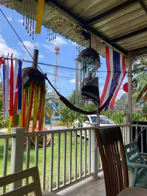 a porch with flags and chairs on a fence at Lay Back Villa Wooden House AC Hot shower High Speed Internet in Krabi town