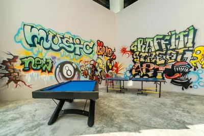 two ping pong tables in front of a wall with graffiti at Private apartment at Twin Sands by Lofty in Patong Beach