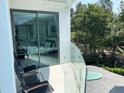 a balcony with chairs and a table on a house at Private apartment at Twin Sands by Lofty in Patong Beach
