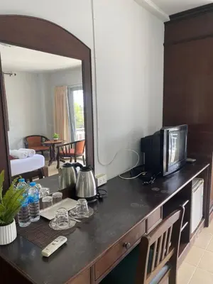 a living room with a television and a mirror at NAKA GUEST HOUSE in Ban Ko Kwang