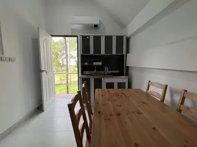 a dining room with a wooden table and chairs at Charming Villa Suite with Balcony near Beach in Patong Beach