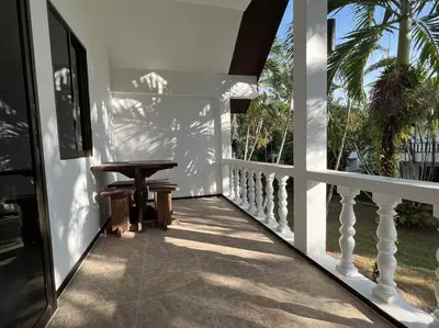 a porch with a table and a bench on a house at Charming Villa Suite with Balcony near Beach in Patong Beach