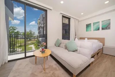 a living room with a couch and a bed and a window at Laguna BangTao Beach Skypark Apartment in Phuket Town