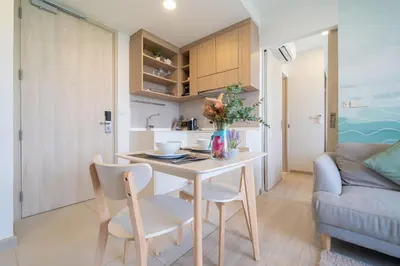 a kitchen and living room with a table and chairs at Laguna BangTao Beach Skypark Apartment in Phuket Town