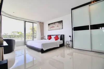 a bedroom with a bed with red pillows on it at Luxury Rooftop Penthouse in Kamala Beach