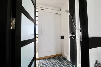 a bathroom with a shower and a glass door at Luxury Rooftop Penthouse in Kamala Beach
