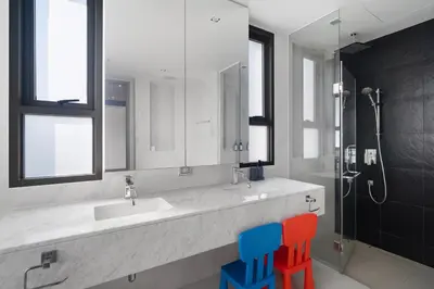 a bathroom with a sink and two colorful chairs at 5 Bdr 18 meter Pool villa in Laguna Phuket in Phuket Town
