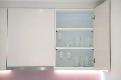 a white cabinet filled with glasses and bowls at 5 Bdr 18 meter Pool villa in Laguna Phuket in Phuket Town