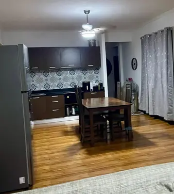 a kitchen with a dining room table and a refrigerator at Villa KEWALYN in Chalong