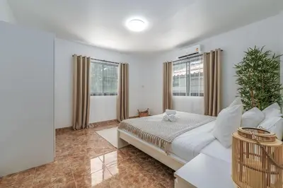 a bedroom with a bed and two windows at Nai Harn beach Villa 2 bdr in Rawai Beach