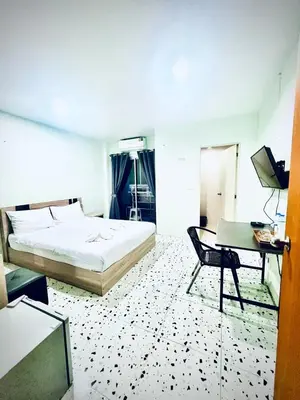 a bedroom with a bed and a table and a desk at BLUE PEARL SHORE in Patong Beach