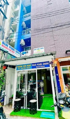 a blue rental shop with a motorcycle parked in front of it at BLUE PEARL SHORE in Patong Beach