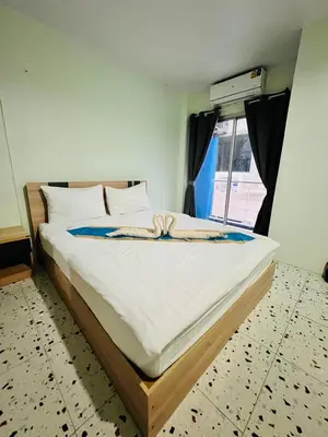 a large bed in a room with a window at BLUE PEARL SHORE in Patong Beach