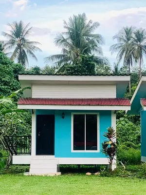 a blue and white house with palm trees in the background at Yada Resort Koh Yao Noi in Ko Yao Noi