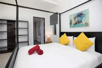 a bedroom with a white bed with a red bow tie on it at Tropical 3BR Pool Villa Prima, just 5min Drive to NaiHarn and Rawai Beach in Rawai Beach