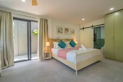 a bedroom with a bed and a large window at Ray Ray Villa by G Estate Phuket in Kata Beach