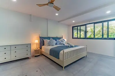 a bedroom with a bed and a ceiling fan at Ray Ray Villa by G Estate Phuket in Kata Beach