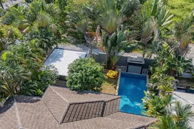 an overhead view of a swimming pool with palm trees at Ray Ray Villa by G Estate Phuket in Kata Beach