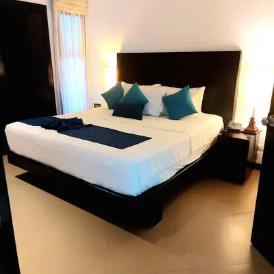 a large bed with blue pillows in a bedroom at Dewa One bedroom suite in Nai Yang Beach