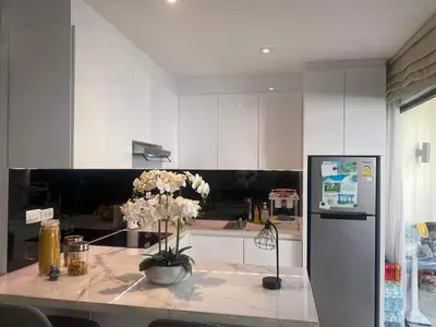 a kitchen with a table with flowers on it at Dewa One bedroom suite in Nai Yang Beach